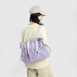 Detailed view of lightweight purple waterproof tote bag with adjustable side drawstrings