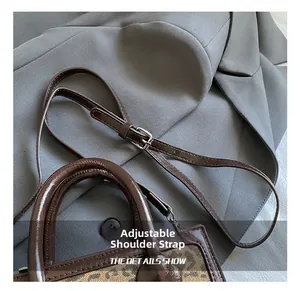 Detail of adjustable shoulder strap and leopard print on a dark brown leather bag