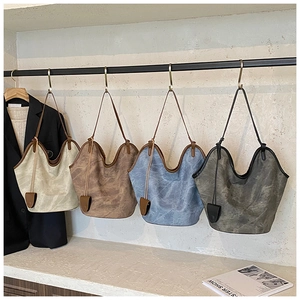 Detail of four large vintage leather tote bags in beige, brown, blue and grey colors