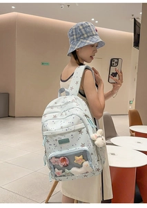 Light blue school backpack with star patterns and a transparent front pocket for pins