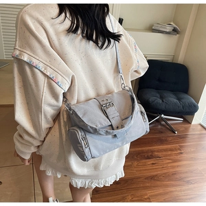 Détail de la sacoche en nylon gris imperméable avec rabat et boucle métallique