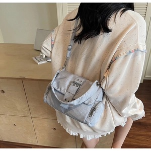 Détail du sac bandoulière bleu clair avec poches zippées et sangle réglable sur le mannequin