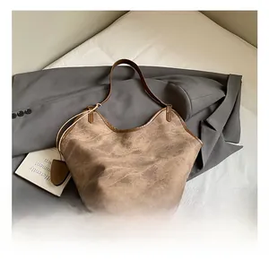 Detail of vintage brown tote bag with wrinkled texture and stylish leather trim details