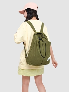 Minimalist olive green nylon drawstring backpack with adjustable straps on female model