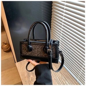 Detail of the leopard print and black patent leather texture on the small crossbody bag
