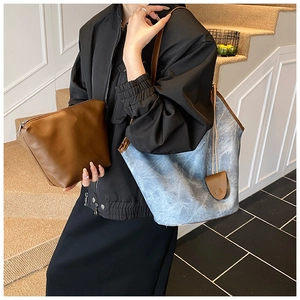 Detail of vintage tote bag set with brown leather trim shown on a lifestyle model