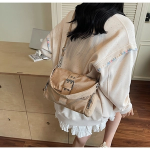 Détail du sac bandoulière en toile kaki avec boucle de ceinture et chaîne en métal