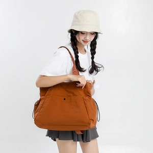 Detail of water-resistant caramel orange tote bag with large front pocket and side drawstring