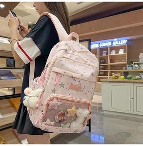 Detail of pink star pattern backpack with transparent window and plush bunny charm