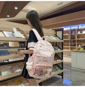 Close-up of pink star pattern school backpack with plush bunny and transparent front pocket
