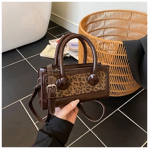 Detailed shot of retro leopard print handbag with glossy brown texture and ball ornaments