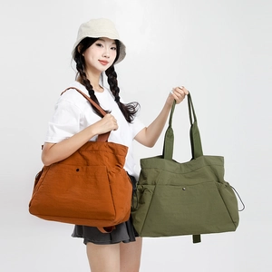 Detail of waterproof nylon tote bags with multiple pockets in caramel and olive green