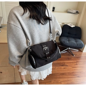 Détails du sac messager en toile noire avec boucles argentées et bandoulière réglable