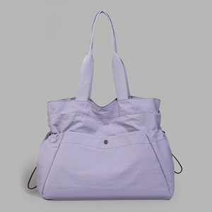 Detail of light purple water-resistant nylon tote bag with wide handles and side drawstrings