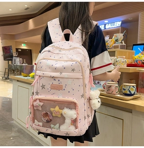 Pink student backpack with star patterns and clear pocket for badges and plush charm