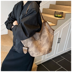 Detail of a large vintage brown marbled tote bag with shoulder strap and matching charm