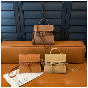 Three vintage matte leather mini crossbody bags in coffee, caramel and beige on a leather bench