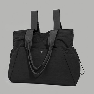 Detail of black waterproof nylon backpack featuring pleated texture and multi-strap design