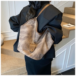 Detail of vintage brown large capacity shoulder bag showing soft leather texture and drape