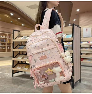 Detailed view of pink school backpack with transparent ITA window and plush charms