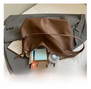 Brown litchi grain leather tote bag showing large capacity for laptop and daily essentials