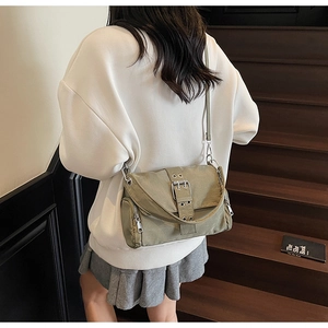 Détail du sac bandoulière en nylon vert olive avec boucle en métal et poche latérale