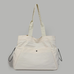 Close-up of cream white waterproof nylon tote bag with magnetic metal buckle and drawstring