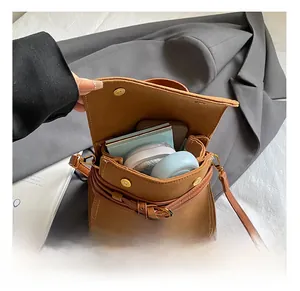 Detail showing the internal storage capacity of the brown frosted square bag with cosmetics