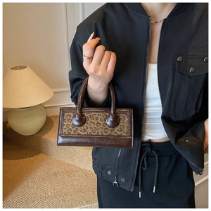 Detail of vintage faux leather handbag with leopard print panel and round handles