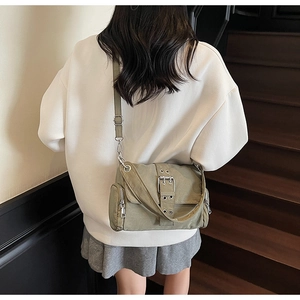 Détail du sac bandoulière en toile vert armée avec ferrures argentées et poches