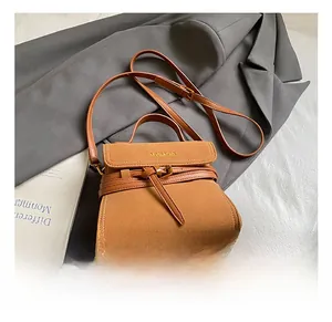 Detail showing brown vintage crossbody bag texture with buckle and stylish strap