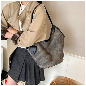 Detail of grey vintage tote bag with black leather trim and marble texture finish
