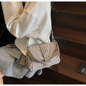 Vue détaillée du sac bandoulière gris en nylon avec boucle métal sur escalier