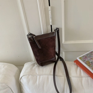 Detail view of dark brown frosted suede and smooth leather stitching bucket bag
