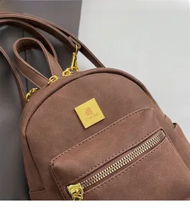 Detailed shot of brown frosted texture backpack with gold hardware and logo branding