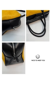 Detail of contrast stitch yellow suede tote bag with silver zippers and black handles