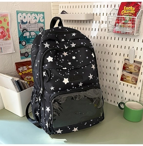 Close-up of black star pattern backpack featuring a transparent PVC front pocket for display