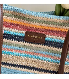 Detail der mehrfarbig gestreiften Strandtasche mit Leder-Markenlogo und Textur