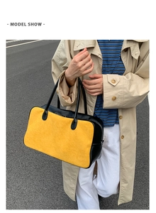 Outdoor model show featuring a large color-block yellow and black leather tote bag