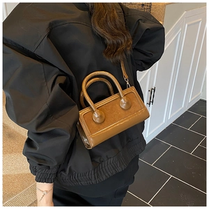Detail of caramel patchwork handbag with shiny leather and suede texture contrast