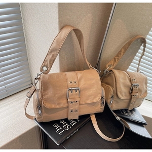 Détail du sac bandoulière en toile kaki avec boucles argentées et poches zippées