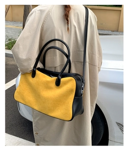 Outdoor shot of a stylish yellow and black contrast tote bag worn on a shoulder