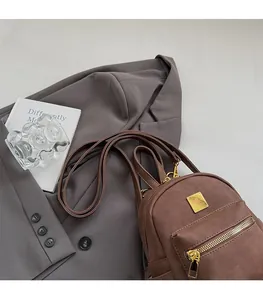 Detail view of vintage dark brown frosted backpack with gold hardware in an aesthetic setting