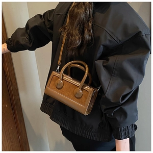 Brown rectangular crossbody bag with dual-texture finish and decorative circular buckles