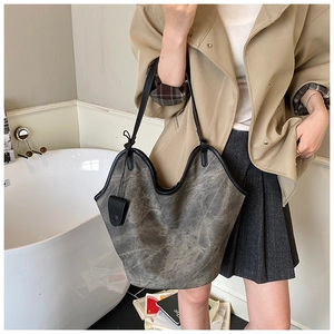 Detail of grey washed canvas tote bag with black wavy trim and leather strap