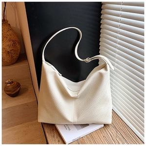 Detailed view of white litchi pattern leather tote bag with soft texture and natural drape