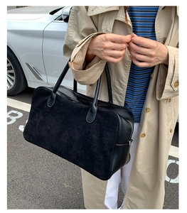 Close-up of a black tote bag featuring a contrast matte and glossy leather finish