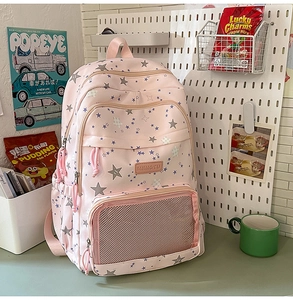 Detail of pink star print backpack with multi-layer zippers and mesh pocket storage