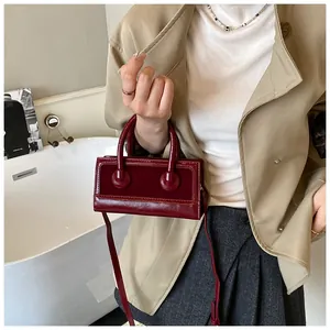 Burgundy rectangular faux leather handbag styled with classic double top handles and thin strap