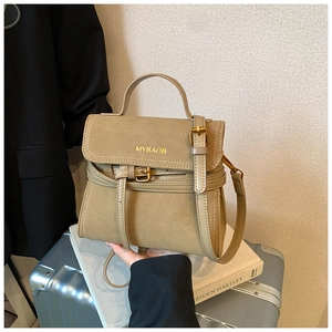 Detailed close-up of retro khaki crossbody bag featuring golden hardware and matte texture